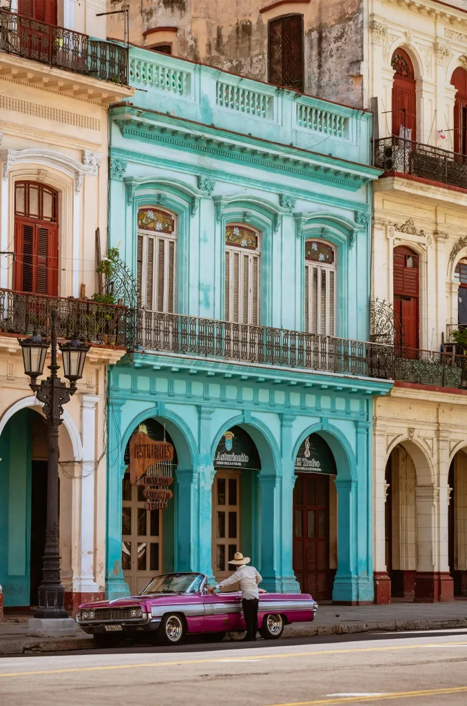 Man Standing beside His Car in front of Colorful Buildings in Havana, Cuba. Photo by Vlad Vasnetsov