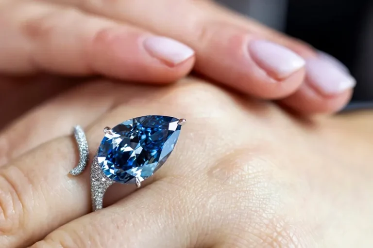 A Christie&rsquo;s employee displays the Mellon Blue, a fancy vivid blue pear-shaped diamond of 9.51 carats, during a preview at Christie&rsquo;s in Geneva, Switzerland, Friday, Nov. 7, 2025, ahead of an auction where it is estimated to sell for between 20 and 30 million US dollars. (Martial Trezzini/Keystone via AP)