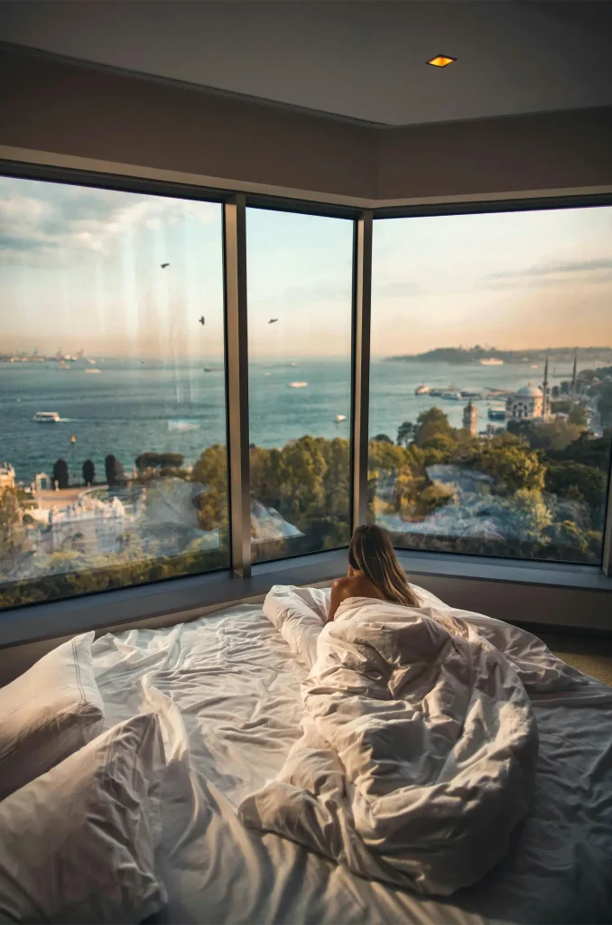 Woman Laying Down on Bed Inside a Hotel Room. Photo by Roberto Nickson
